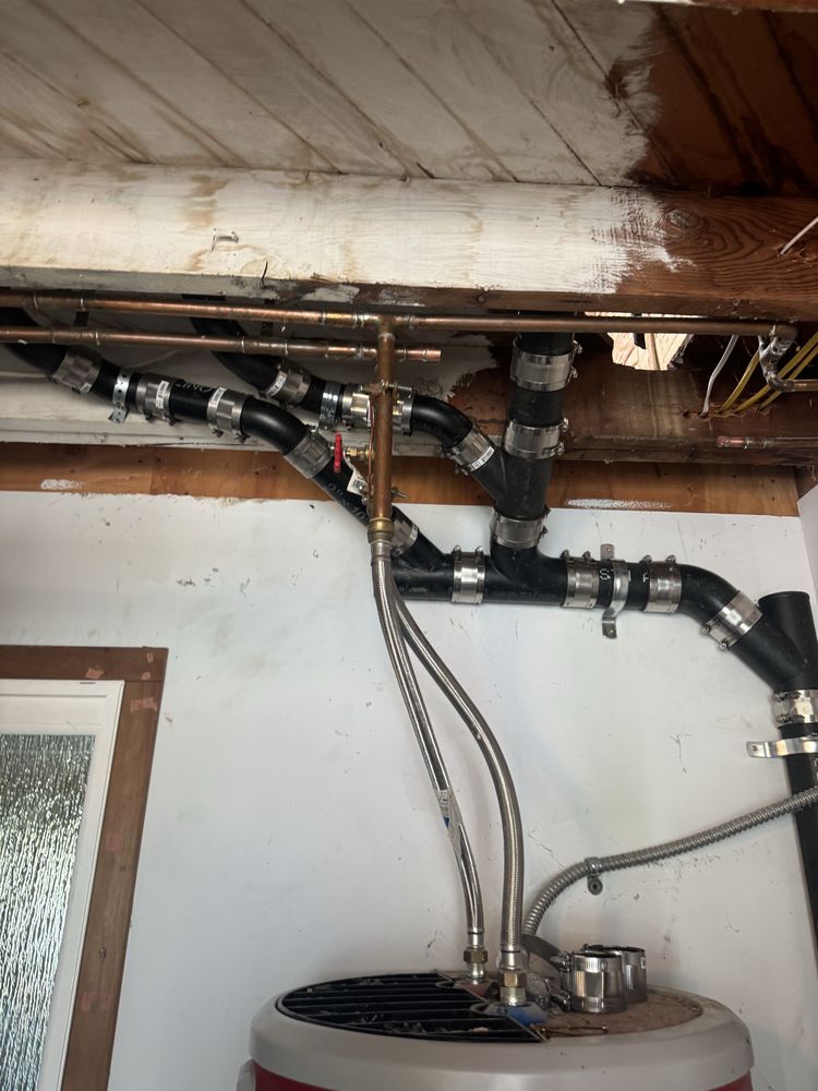 Organized copper and PEX manifold plumbing installed above a water heater